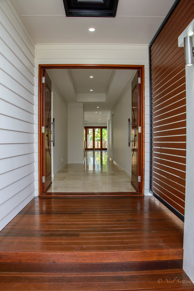 Inspiration for a beach style entry hall in Sunshine Coast with porcelain floors, a double front door, white walls, a medium wood front door and beige floor.