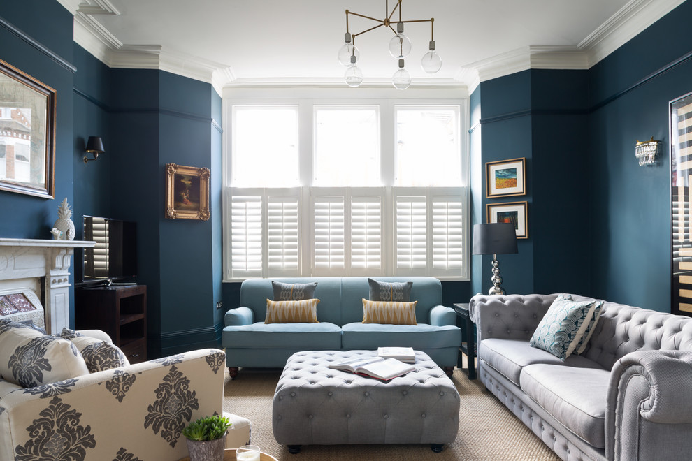 Transitional formal living room in London with blue walls and a standard fireplace.
