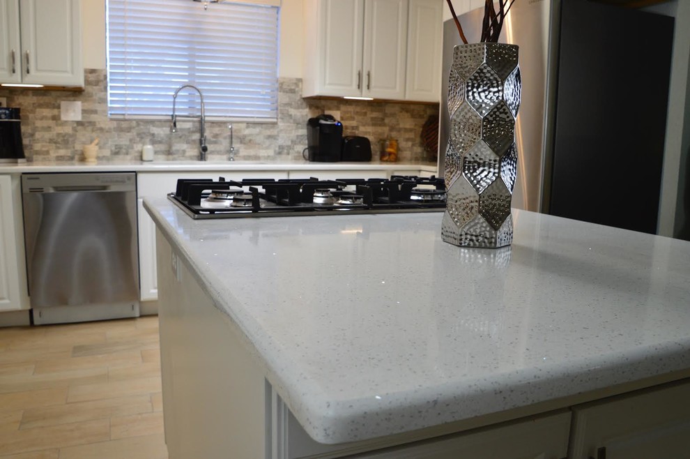 Inspiration for a mid-sized transitional l-shaped porcelain tile enclosed kitchen remodel in Austin with an undermount sink, raised-panel cabinets, white cabinets, quartz countertops, beige backsplash, porcelain backsplash, stainless steel appliances and no island