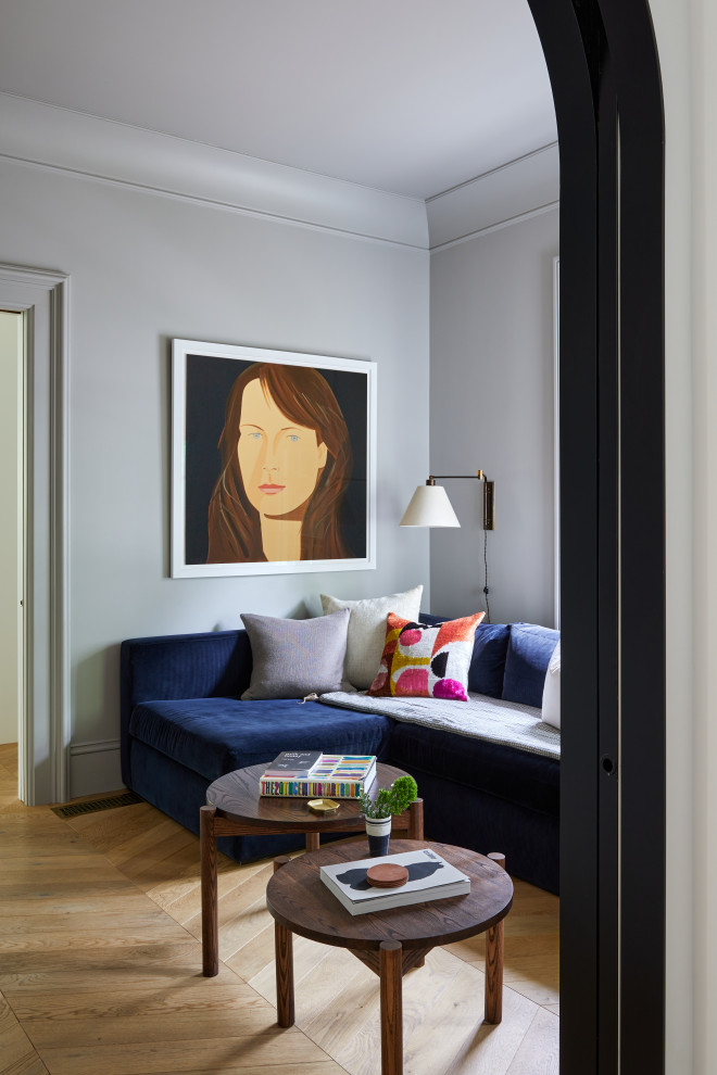 Ejemplo de sala de estar cerrada tradicional renovada pequeña con paredes grises, suelo de madera en tonos medios, televisor retractable y suelo amarillo