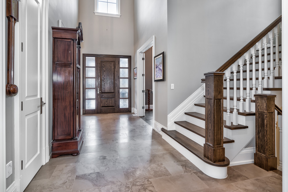 Inspiration for a large transitional porcelain tile and beige floor foyer remodel in Toronto with gray walls and a dark wood front door