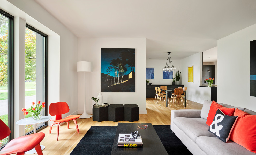 Cette image montre un grand salon minimaliste ouvert avec un mur blanc et parquet clair.