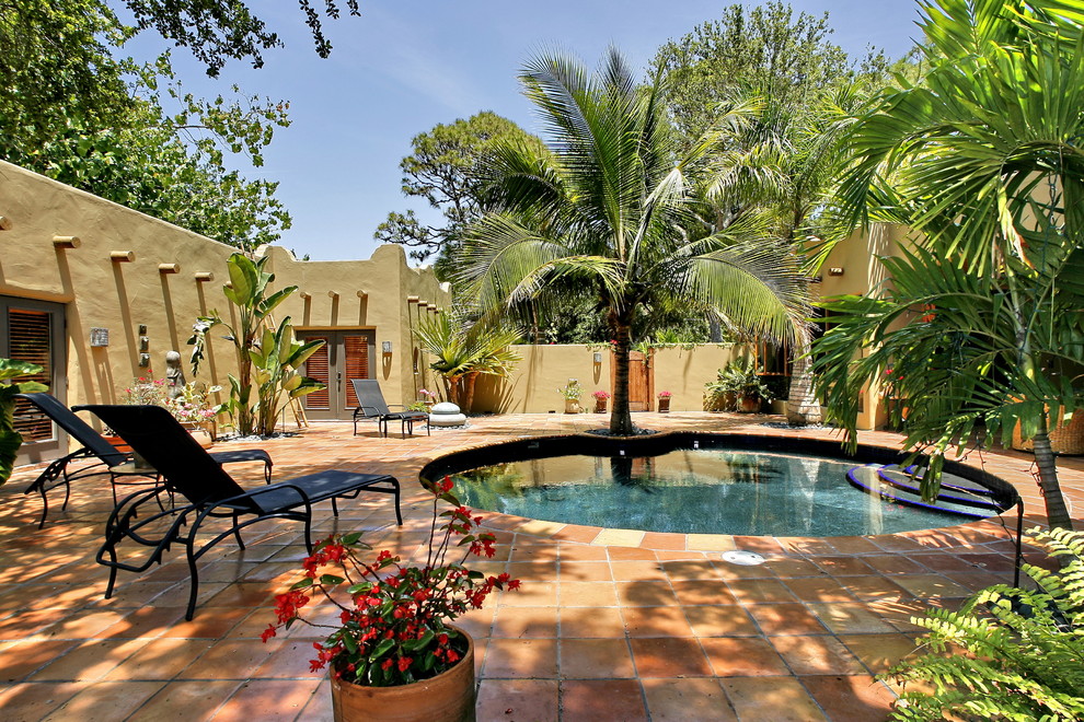 Backyard round pool in Tampa with tile.