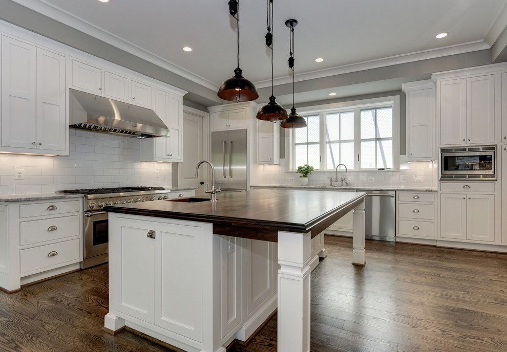 Example of a large country u-shaped medium tone wood floor open concept kitchen design in DC Metro with an undermount sink, shaker cabinets, white cabinets, quartzite countertops, white backsplash, subway tile backsplash, stainless steel appliances and an island