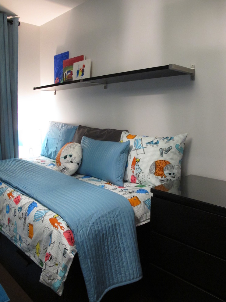 This is an example of a mid-sized contemporary kids' bedroom for kids 4-10 years old and boys in Montreal with blue walls, dark hardwood floors and brown floor.