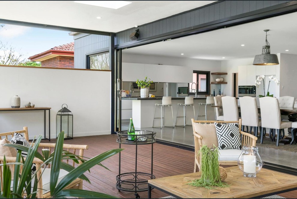Photo of a mid-sized contemporary backyard patio in Sydney with decking and a roof extension.