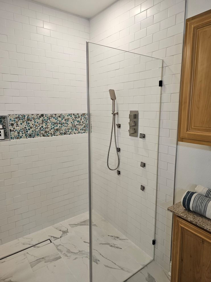 Cette image montre une salle de bain principale vintage de taille moyenne avec une douche à l'italienne, un carrelage blanc, des carreaux de céramique, un sol en carrelage de porcelaine, un sol multicolore, une cabine de douche à porte battante et un banc de douche.