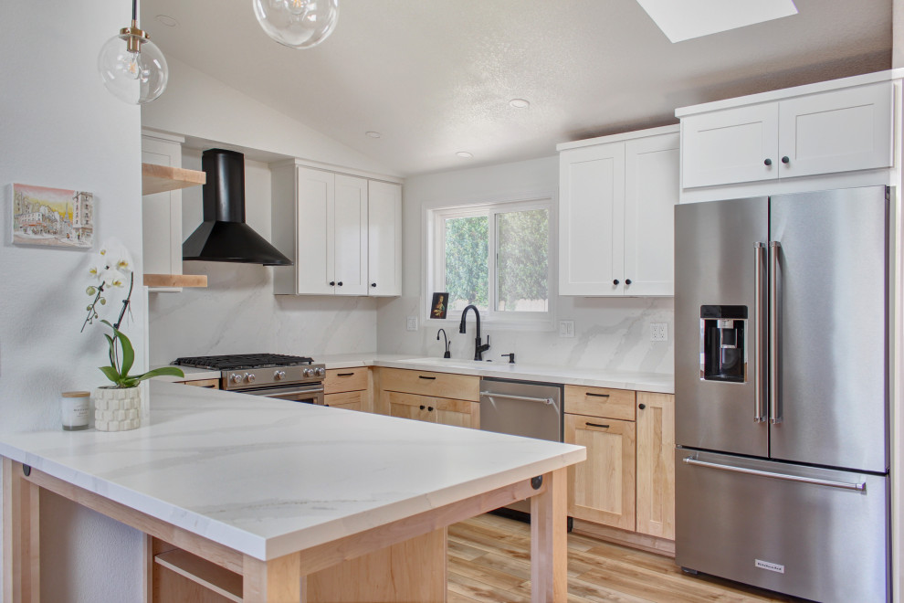 Mid-sized danish u-shaped light wood floor, brown floor and vaulted ceiling kitchen photo in Other with an undermount sink, shaker cabinets, light wood cabinets, quartz countertops, white backsplash, quartz backsplash, stainless steel appliances, a peninsula and white countertops