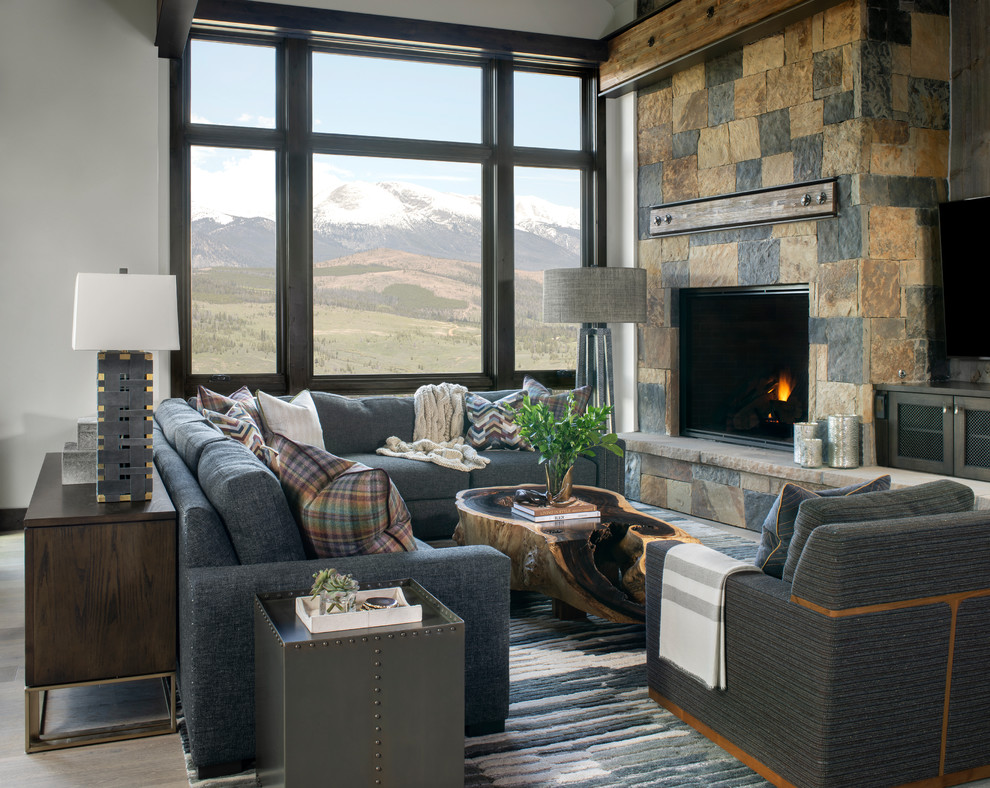 Country formal open concept living room in Denver with white walls, a standard fireplace, a stone fireplace surround, no tv and light hardwood floors.