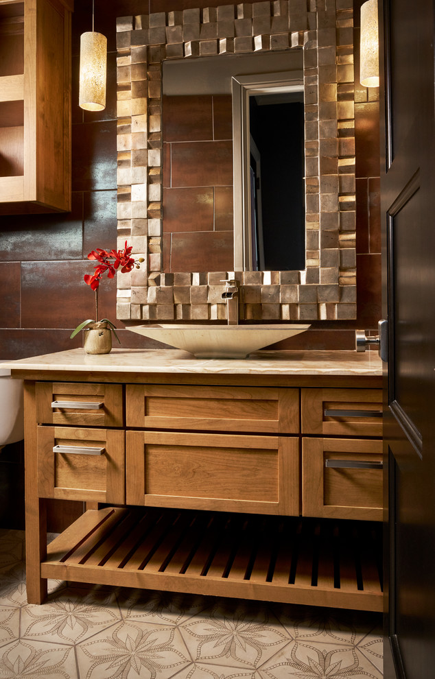 Design ideas for a mid-sized transitional powder room in Other with medium wood cabinets, brown tile, brown walls, a vessel sink, marble benchtops, beige floor, furniture-like cabinets and beige benchtops.
