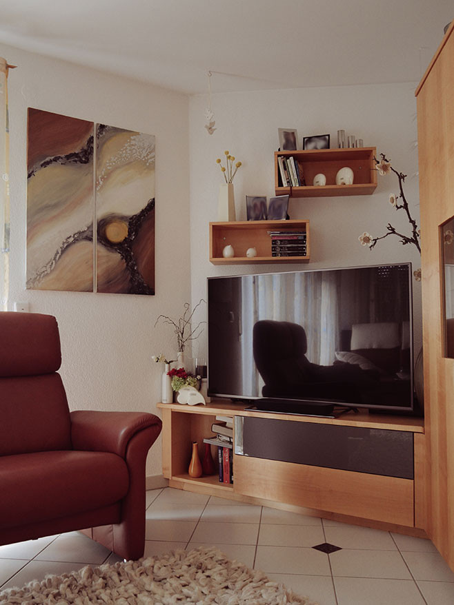 Aménagement d'un salon contemporain fermé avec un mur blanc, un téléviseur d'angle et un sol blanc.