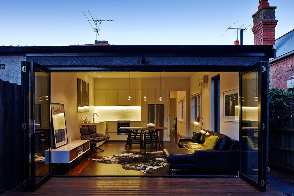 This is an example of a small contemporary open concept living room in Melbourne with white walls and dark hardwood floors.