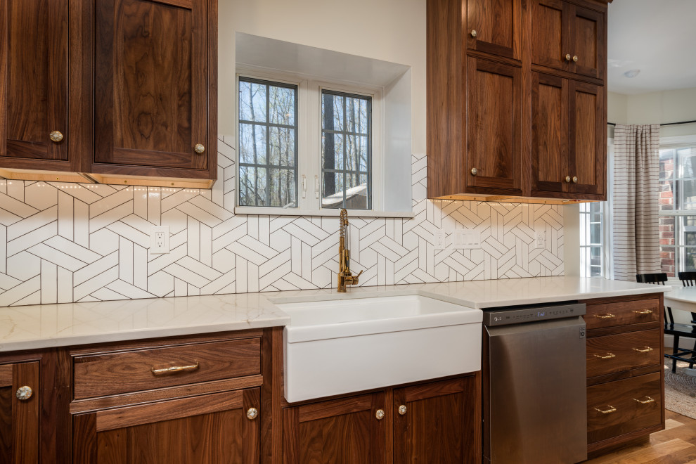 Eat-in kitchen - mid-sized transitional u-shaped medium tone wood floor eat-in kitchen idea with a farmhouse sink, beaded inset cabinets, medium tone wood cabinets, white backsplash, stainless steel appliances and an island