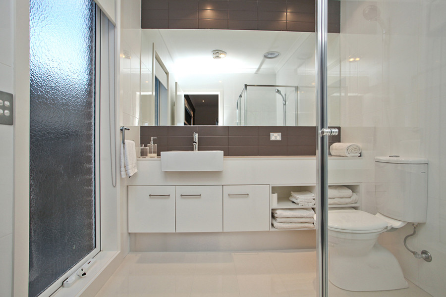 Inspiration for a modern master bathroom in Melbourne with a corner shower, a one-piece toilet and porcelain floors.