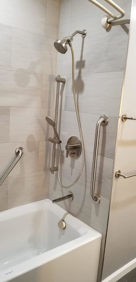 This is an example of a mid-sized modern master bathroom in San Francisco with shaker cabinets, grey cabinets, an alcove tub, a shower/bathtub combo, gray tile, porcelain tile, grey walls, an undermount sink, engineered quartz benchtops, brown floor, a shower curtain and white benchtops.