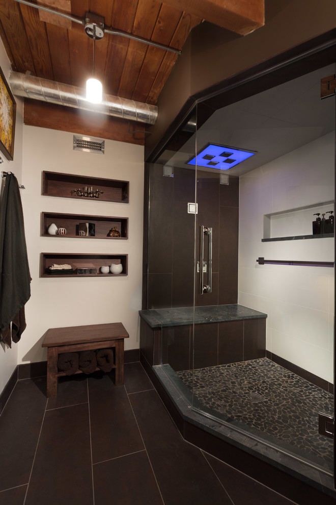 This is an example of a mid-sized industrial bathroom in Chicago with flat-panel cabinets, medium wood cabinets, a wall-mount toilet, multi-coloured tile, pebble tile, white walls, ceramic floors, a wall-mount sink, engineered quartz benchtops and with a sauna.