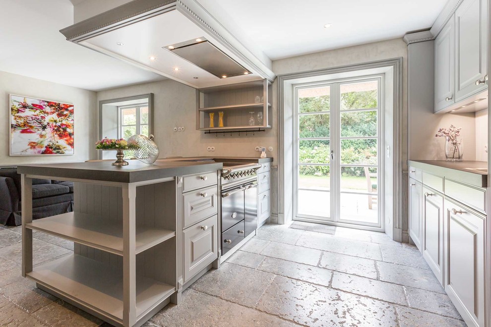 Mid-sized country galley separate kitchen in Other with shaker cabinets, white cabinets, black appliances, slate floors, a peninsula and beige floor.
