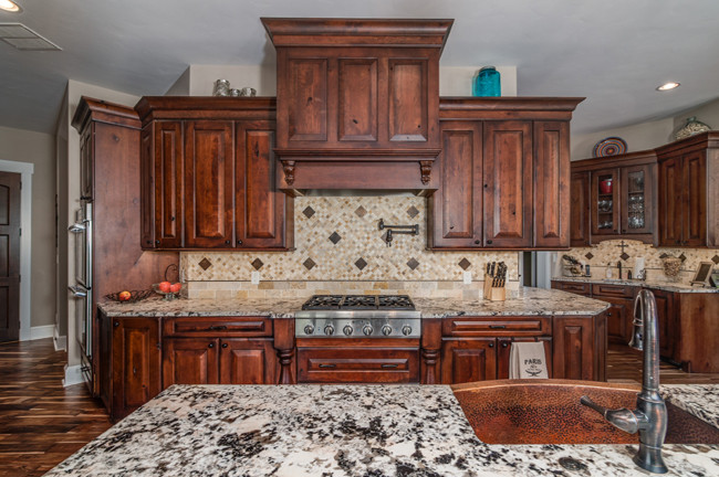 Open concept kitchen - rustic dark wood floor open concept kitchen idea with a farmhouse sink, dark wood cabinets, granite countertops, beige backsplash, an island and white countertops