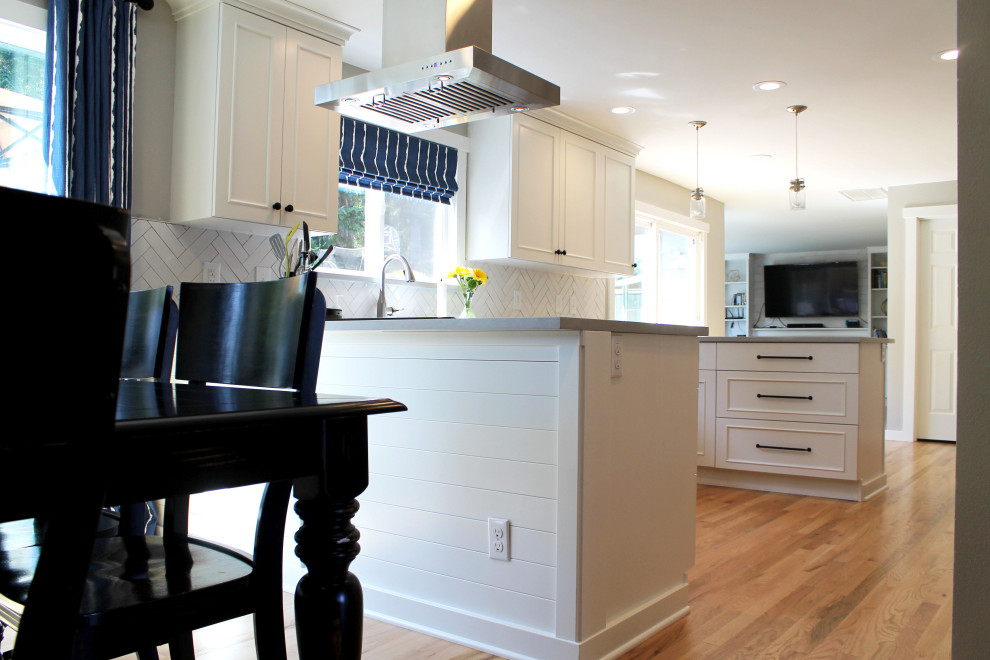 Inspiration for a mid-sized transitional u-shaped medium tone wood floor eat-in kitchen remodel in Seattle with an undermount sink, shaker cabinets, white cabinets, quartz countertops, white backsplash, ceramic backsplash, stainless steel appliances, a peninsula and gray countertops