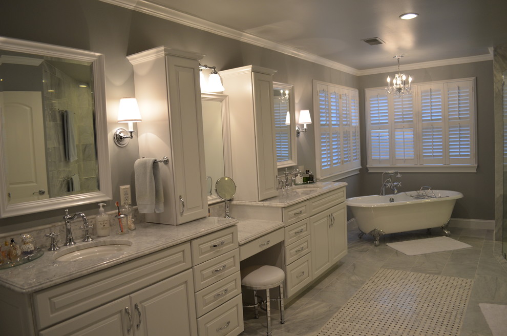 Photo of a large traditional master bathroom in Philadelphia with raised-panel cabinets, white cabinets, a claw-foot tub, a curbless shower, a two-piece toilet, white tile, stone tile, grey walls, marble floors, an undermount sink and marble benchtops.