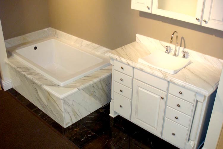 This is an example of a mid-sized traditional master bathroom in Seattle with furniture-like cabinets, white cabinets, a drop-in tub, beige walls, marble floors, a drop-in sink, marble benchtops, black floor and white benchtops.