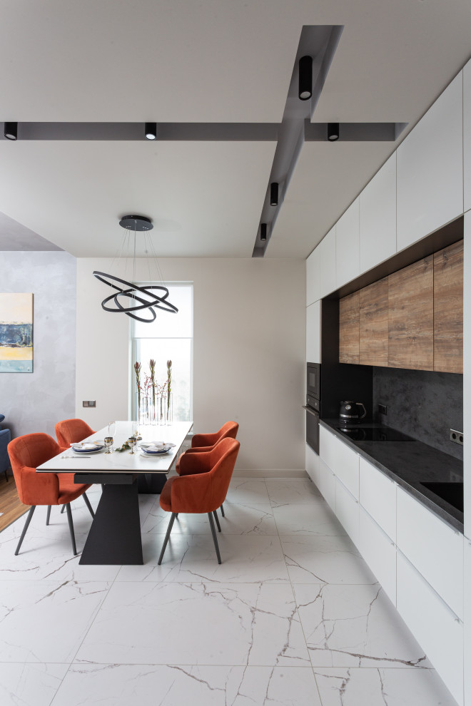 Mid-sized contemporary single-wall eat-in kitchen in Yekaterinburg with a single-bowl sink, flat-panel cabinets, white cabinets, solid surface benchtops, black splashback, black appliances, porcelain floors, white floor and black benchtop.