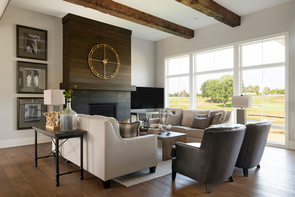 Country living room in Minneapolis with grey walls, dark hardwood floors, a standard fireplace, a metal fireplace surround and brown floor.