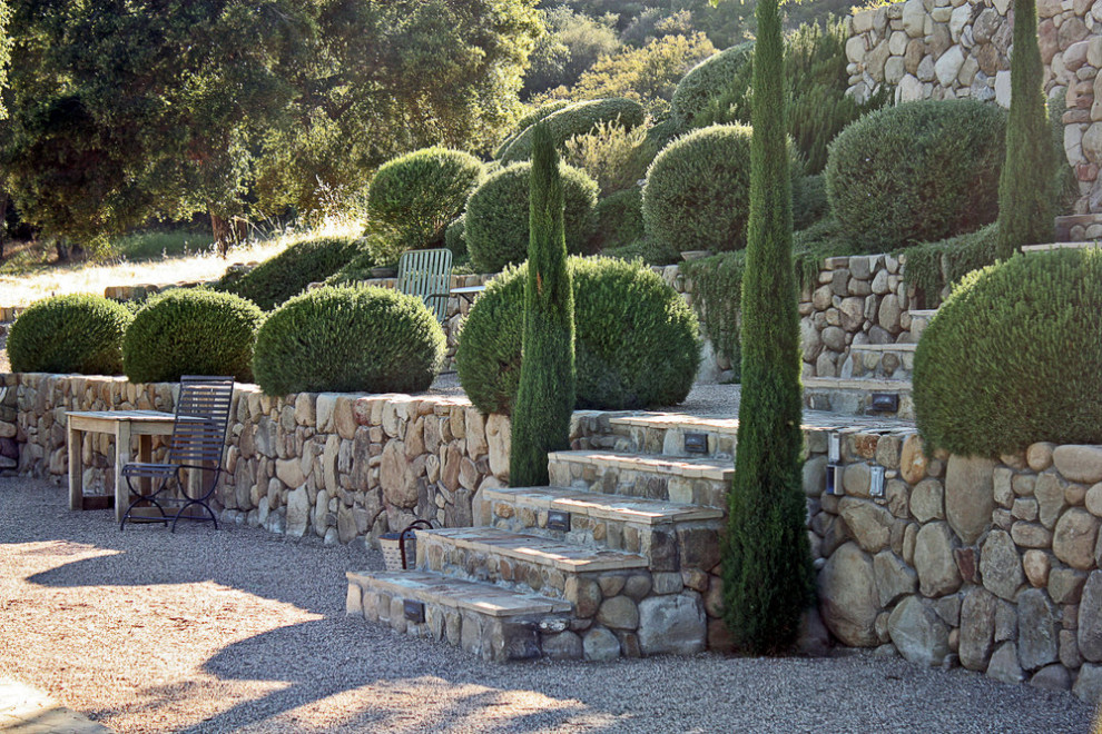 This is an example of a farmhouse back formal garden in Santa Barbara with a rockery and natural stone paving.