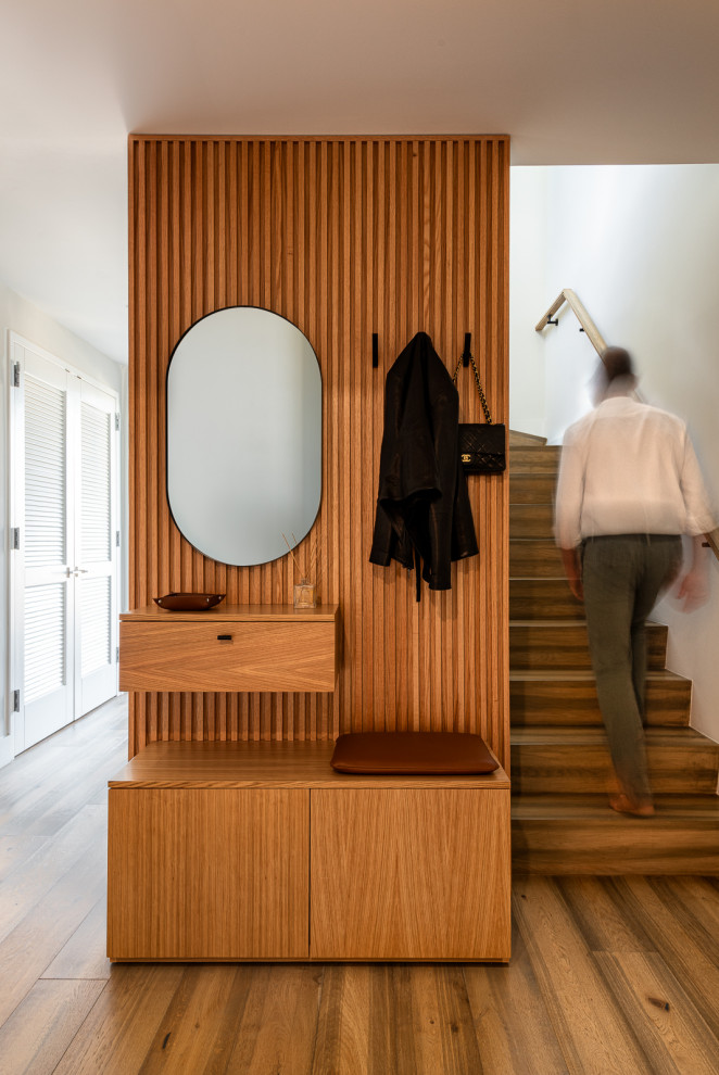 Kleines Modernes Foyer mit grauer Wandfarbe, braunem Holzboden, Einzeltür und braunem Boden in New York
