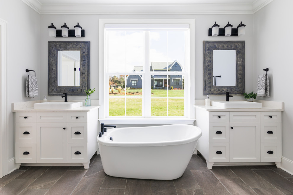 Inspiration for a traditional ensuite bathroom in Other with shaker cabinets, white cabinets, a freestanding bath, white tiles, white walls, porcelain flooring, a vessel sink, engineered stone worktops, grey floors, white worktops, a single sink and a freestanding vanity unit.