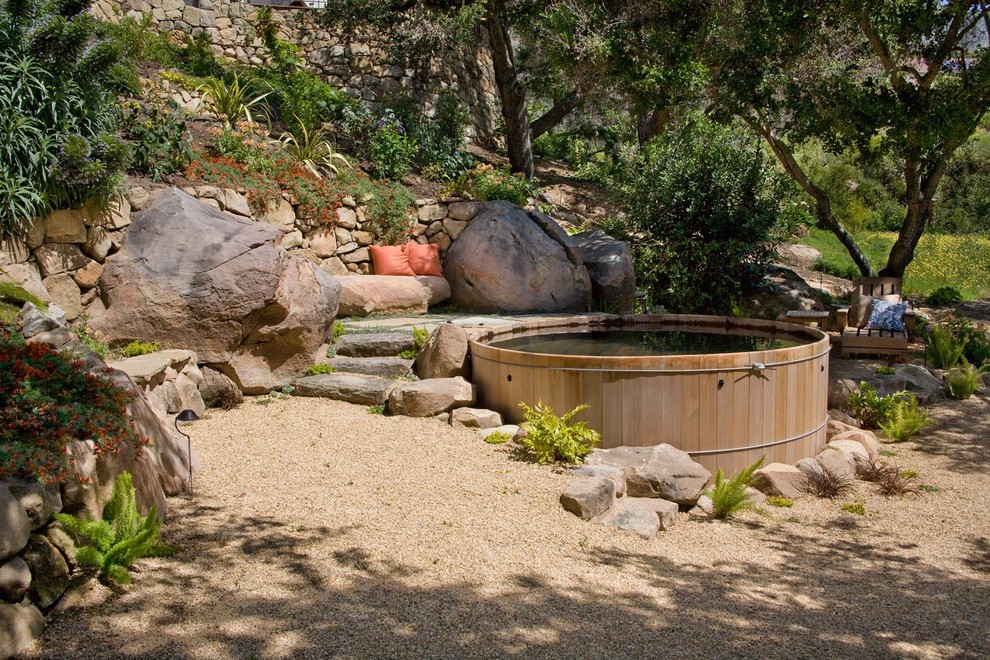 This is an example of a mediterranean round aboveground pool in Santa Barbara with a water feature and gravel.
