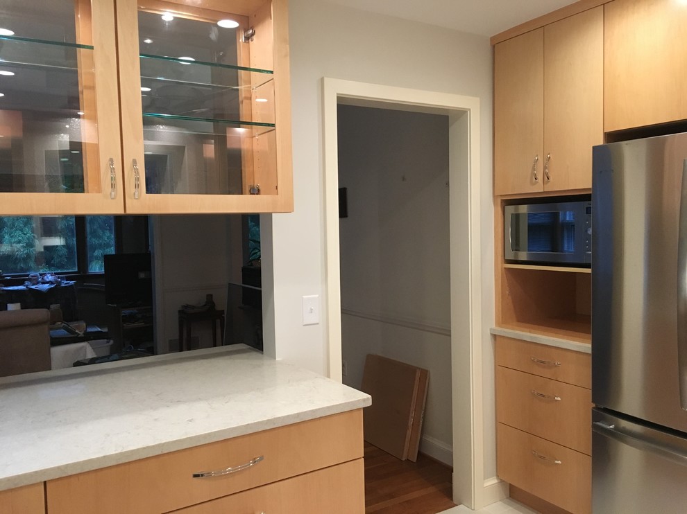 Inspiration for a mid-sized transitional u-shaped porcelain tile and gray floor enclosed kitchen remodel in DC Metro with an undermount sink, flat-panel cabinets, medium tone wood cabinets, quartz countertops, white backsplash, porcelain backsplash, stainless steel appliances and no island