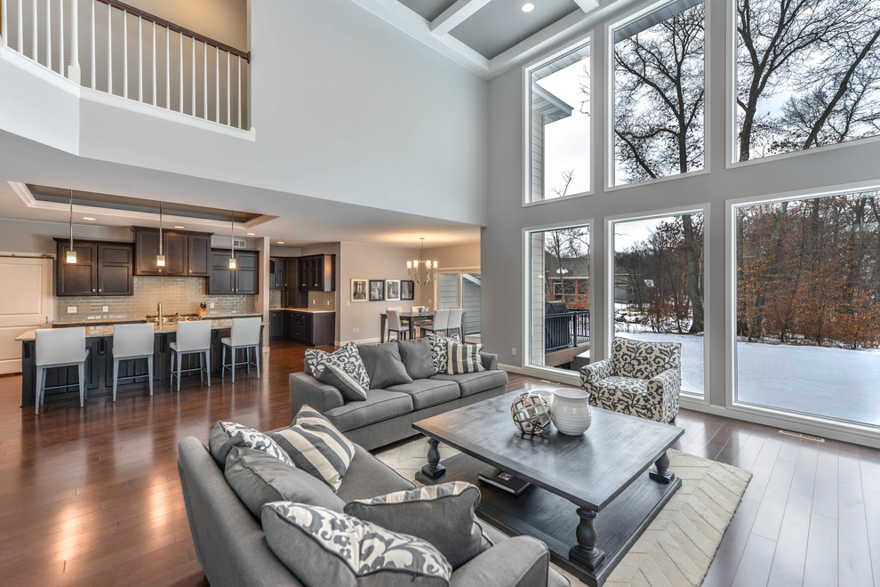 Large modern open concept living room in Minneapolis with grey walls, dark hardwood floors, a standard fireplace, a stone fireplace surround and a wall-mounted tv.