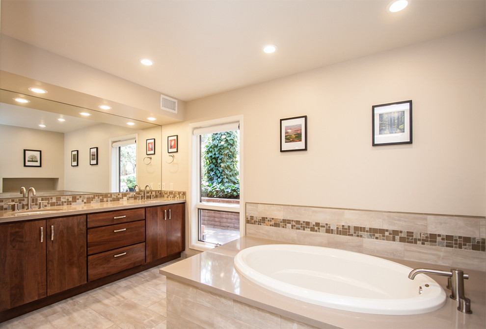 Example of a large transitional master beige tile and porcelain tile porcelain tile and beige floor drop-in bathtub design in Phoenix with flat-panel cabinets, dark wood cabinets, beige walls, an undermount sink and granite countertops