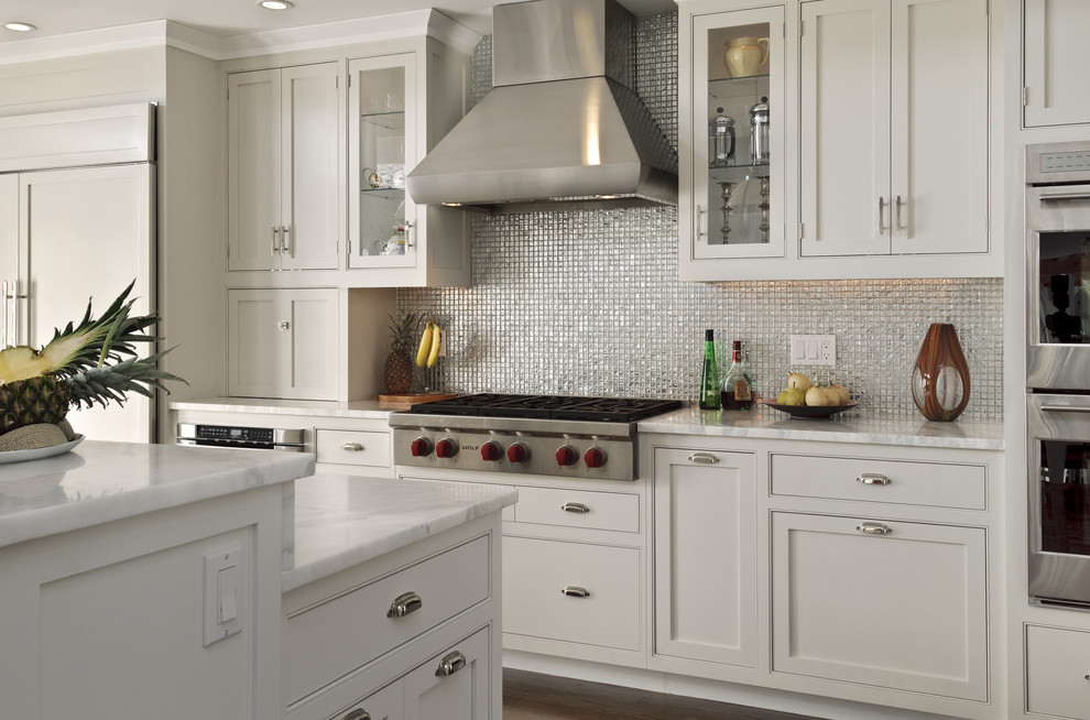 Traditional eat-in kitchen in New York with shaker cabinets, white cabinets, metallic splashback, mosaic tile splashback, stainless steel appliances, a drop-in sink and marble benchtops.