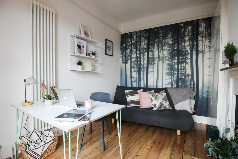Skandinavisk inredning av ett litet hemmastudio, med flerfärgade väggar, mellanmörkt trägolv, en standard öppen spis, en spiselkrans i metall, ett fristående skrivbord och brunt golv