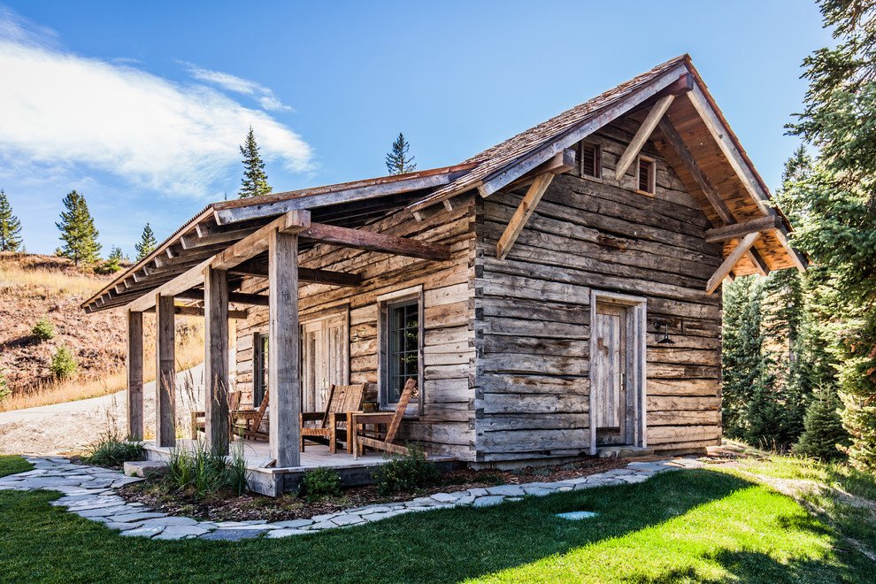 This is an example of a mid-sized country one-storey brown exterior in Other with wood siding and a gable roof.