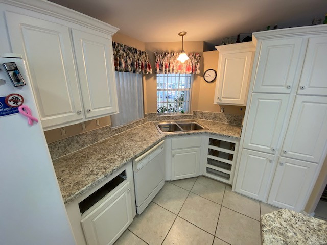 Example of a mid-sized u-shaped eat-in kitchen design with a double-bowl sink, raised-panel cabinets, white cabinets, laminate countertops, an island and white countertops