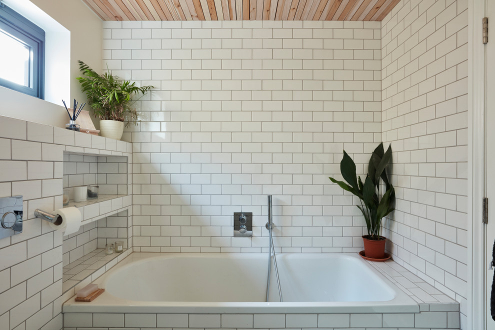 This is an example of a small 3/4 bathroom in London with a drop-in tub, a corner shower, a one-piece toilet, white tile, ceramic tile, white walls, slate floors, a trough sink, grey floor, an open shower, a single vanity, a freestanding vanity and timber.