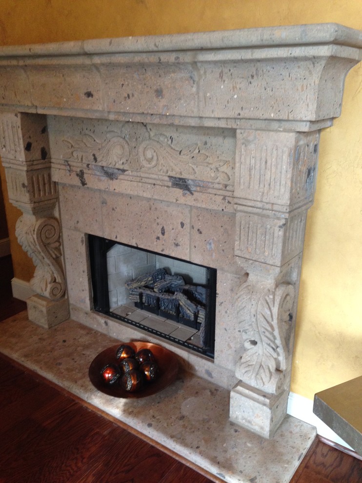 Example of a tuscan living room design in Dallas with a standard fireplace and a stone fireplace