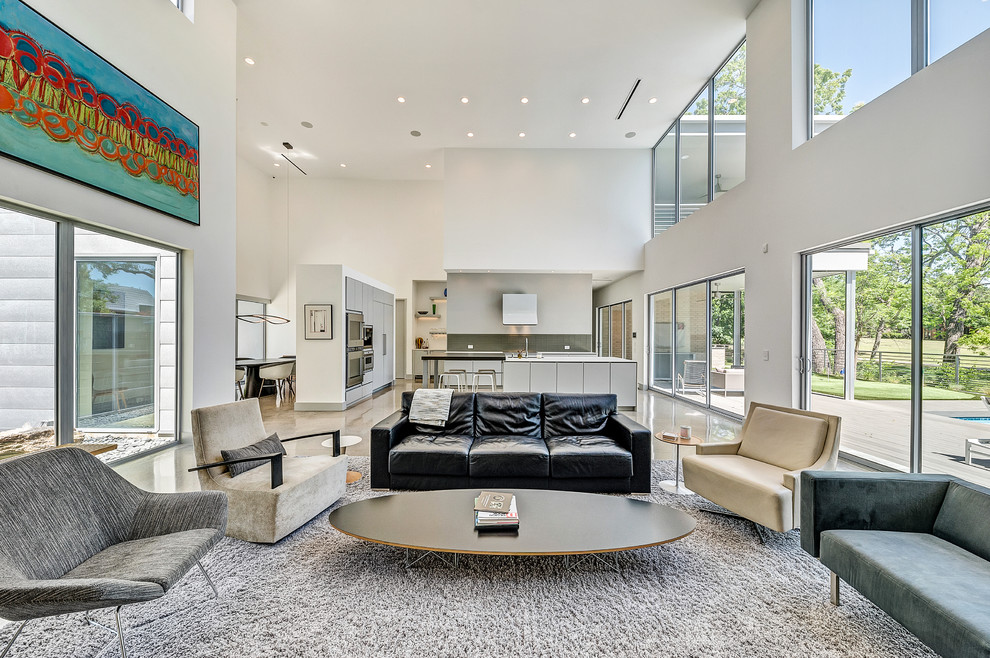 This is an example of an expansive modern formal open concept living room in Dallas with white walls, concrete floors, a hanging fireplace, a brick fireplace surround, a wall-mounted tv and multi-coloured floor.