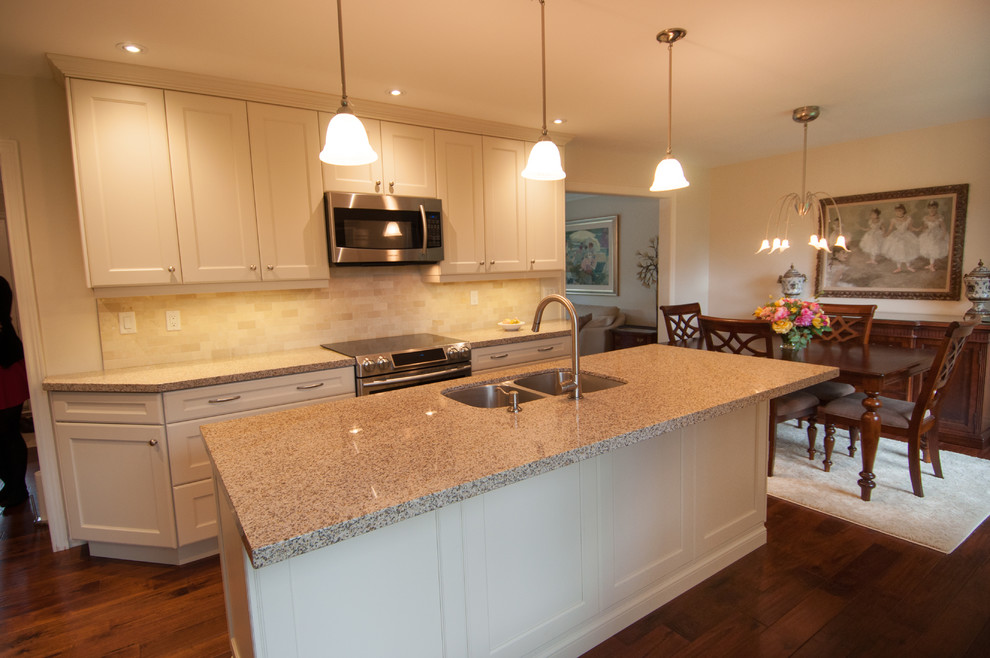 Mid-sized transitional l-shaped dark wood floor eat-in kitchen photo in Toronto with a double-bowl sink, shaker cabinets, white cabinets, granite countertops, beige backsplash, ceramic backsplash, paneled appliances and an island