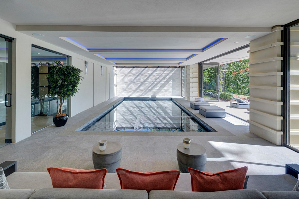 This is an example of a contemporary indoor rectangular pool in Detroit with a hot tub and tile.