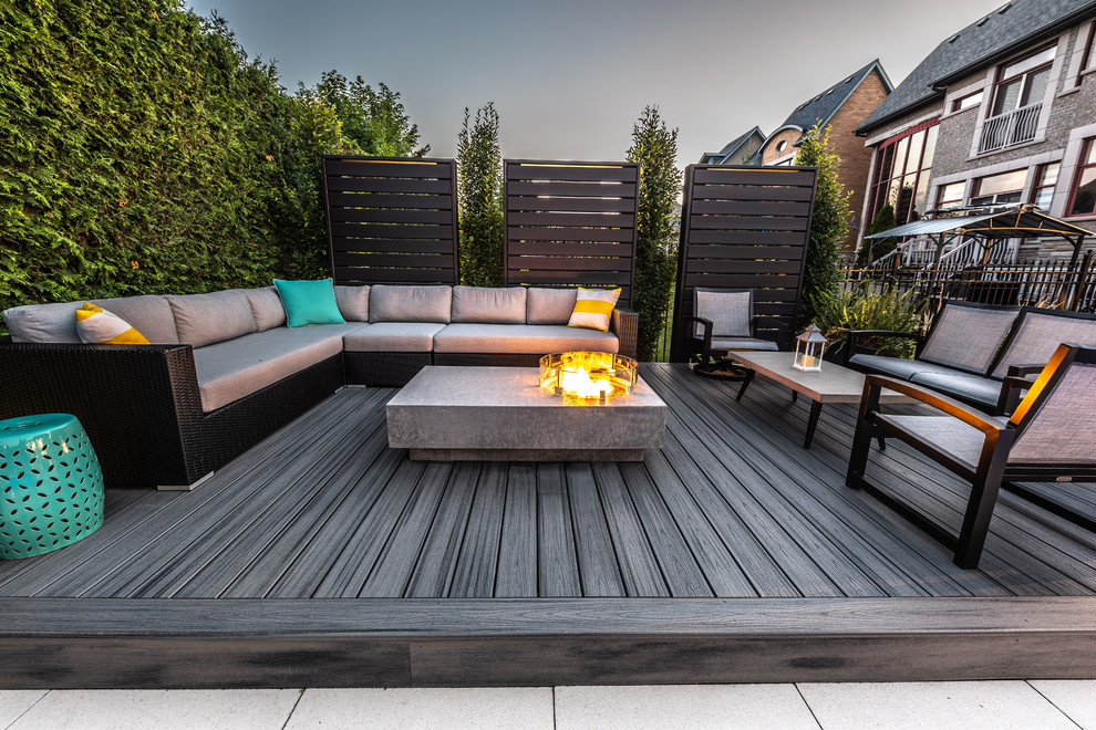 Mid-sized transitional backyard deck in Toronto with a fire feature and no cover.