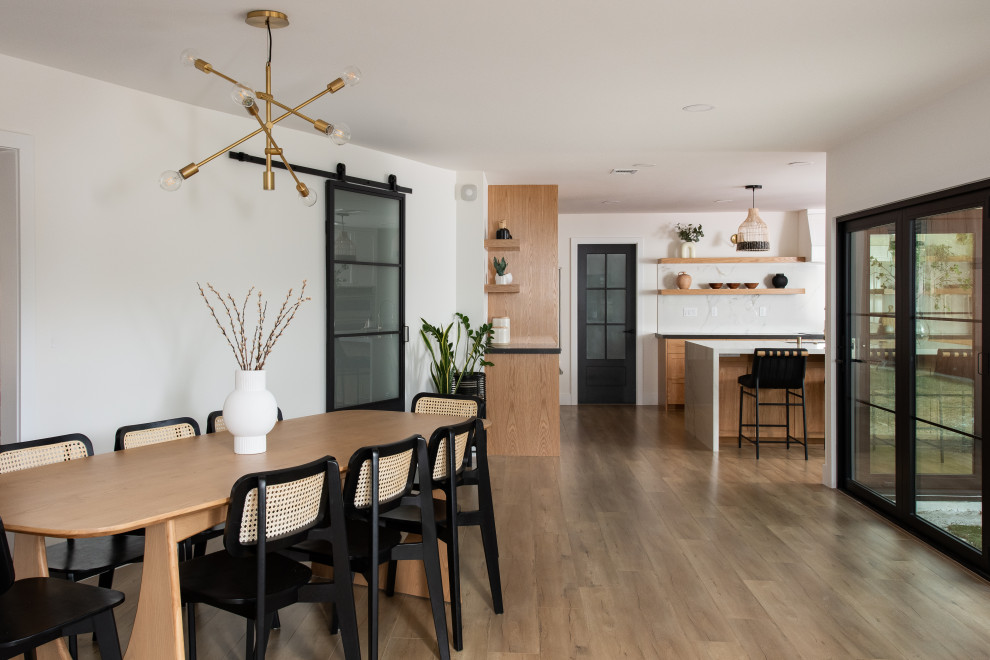 Immagine di una sala da pranzo aperta verso la cucina stile marinaro di medie dimensioni con pavimento in legno massello medio