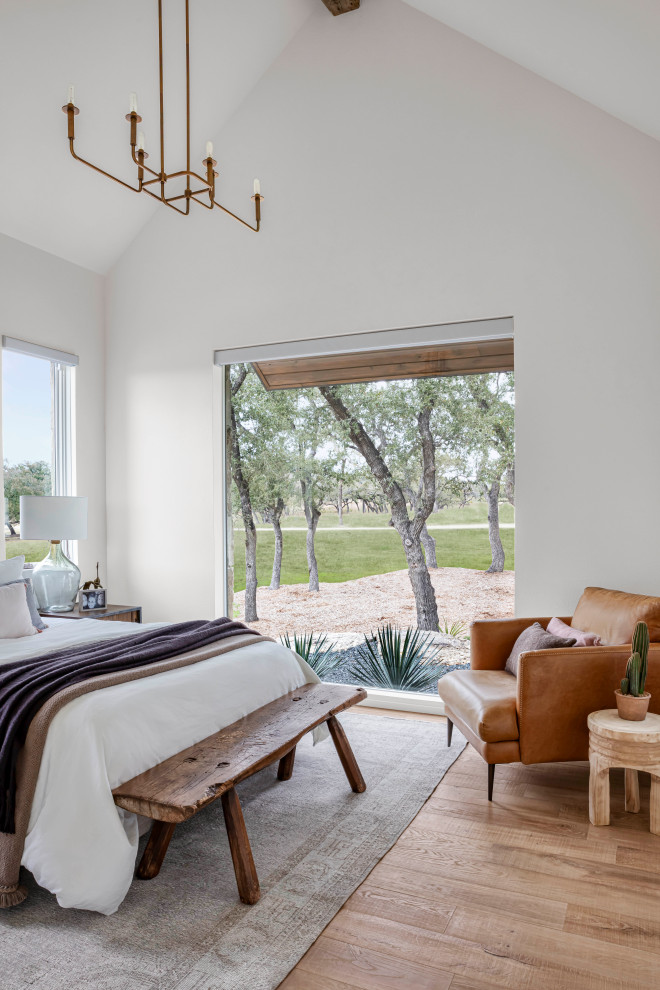 Landhausstil Gästezimmer mit weißer Wandfarbe, hellem Holzboden und gewölbter Decke in Austin