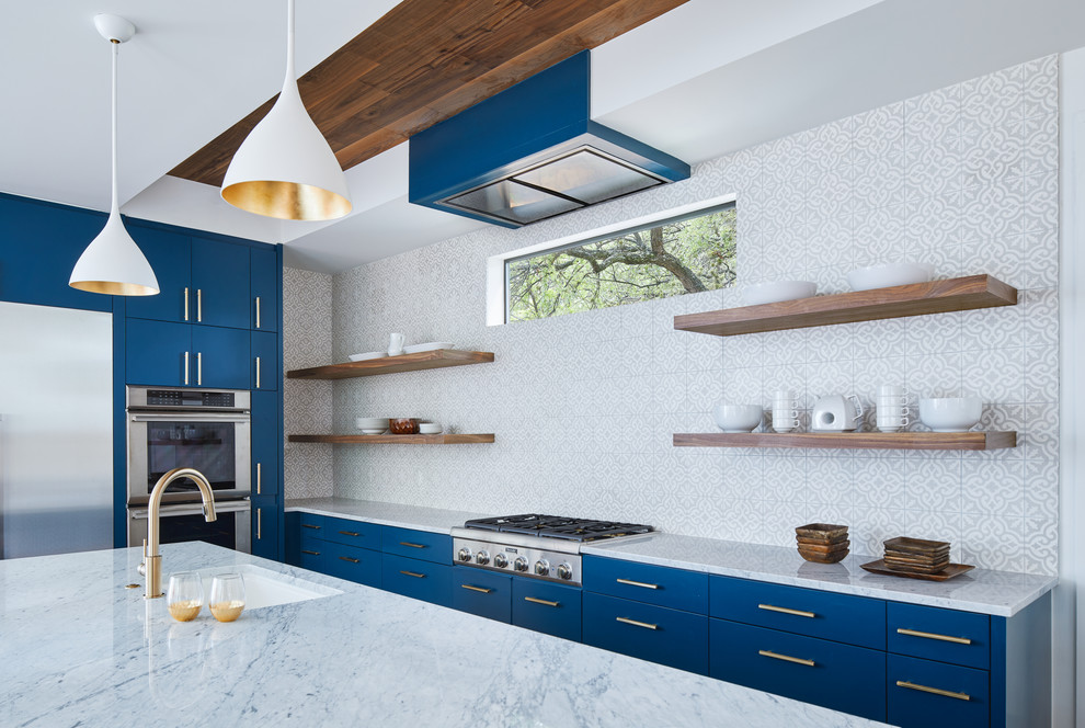 This is an example of a large modern open plan kitchen in Austin with an undermount sink, flat-panel cabinets, blue cabinets, marble benchtops, cement tile splashback, stainless steel appliances, dark hardwood floors, with island and white benchtop.
