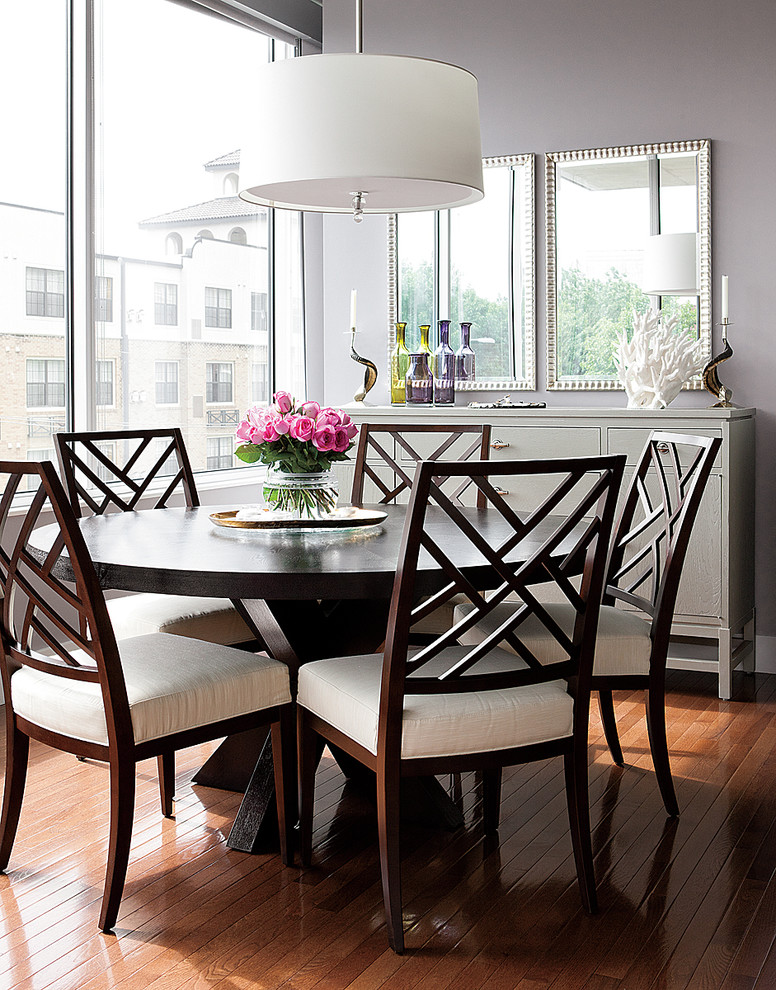 This is an example of a transitional dining room in Kansas City with grey walls and dark hardwood floors.
