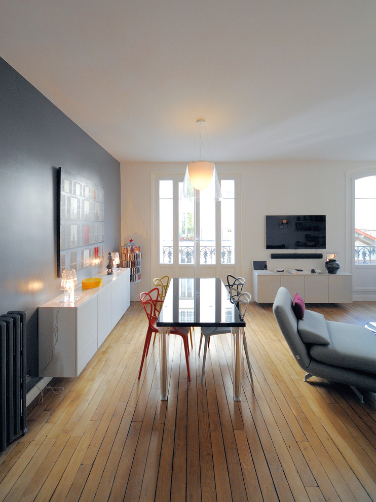 Photo of a mid-sized contemporary open plan dining in Paris with medium hardwood floors, no fireplace and grey walls.