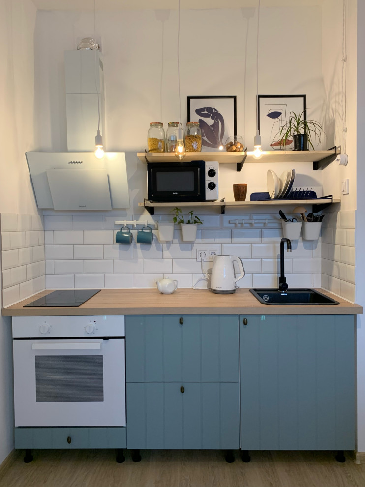 Photo of a small scandinavian single-wall eat-in kitchen in Saint Petersburg with an undermount sink, raised-panel cabinets, turquoise cabinets, wood benchtops, white splashback, subway tile splashback, white appliances, laminate floors, no island, beige floor and beige benchtop.